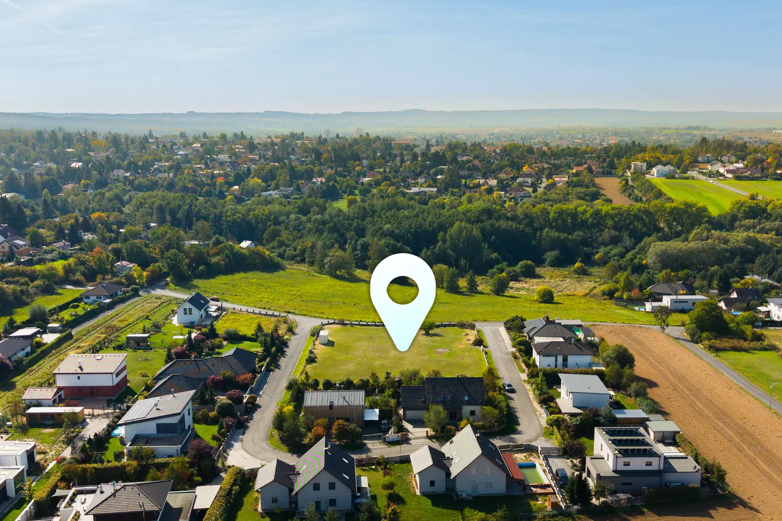 Pacov z dronu, místo parcel označené špendlíkem, za ním les a Říčany